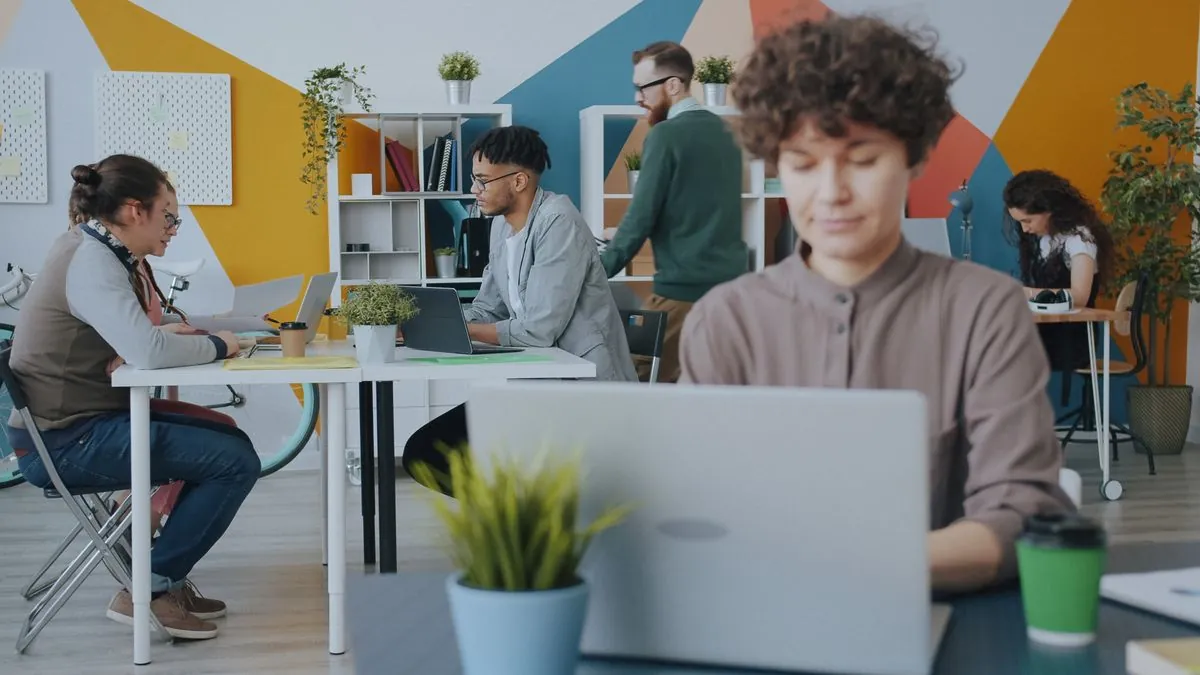 Espace de travail créatif où une équipe collabore autour de documents et d'écrans